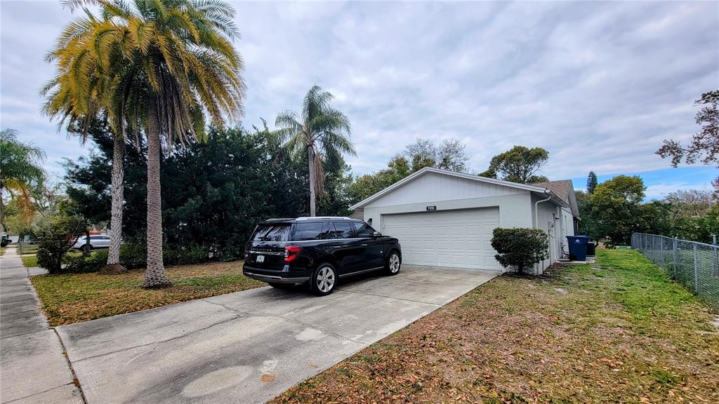 A black SUV is parked in the concrete driveway of a single-story house — 7051 WENTWORTH WAY, NEW PORT RICHEY, FL
