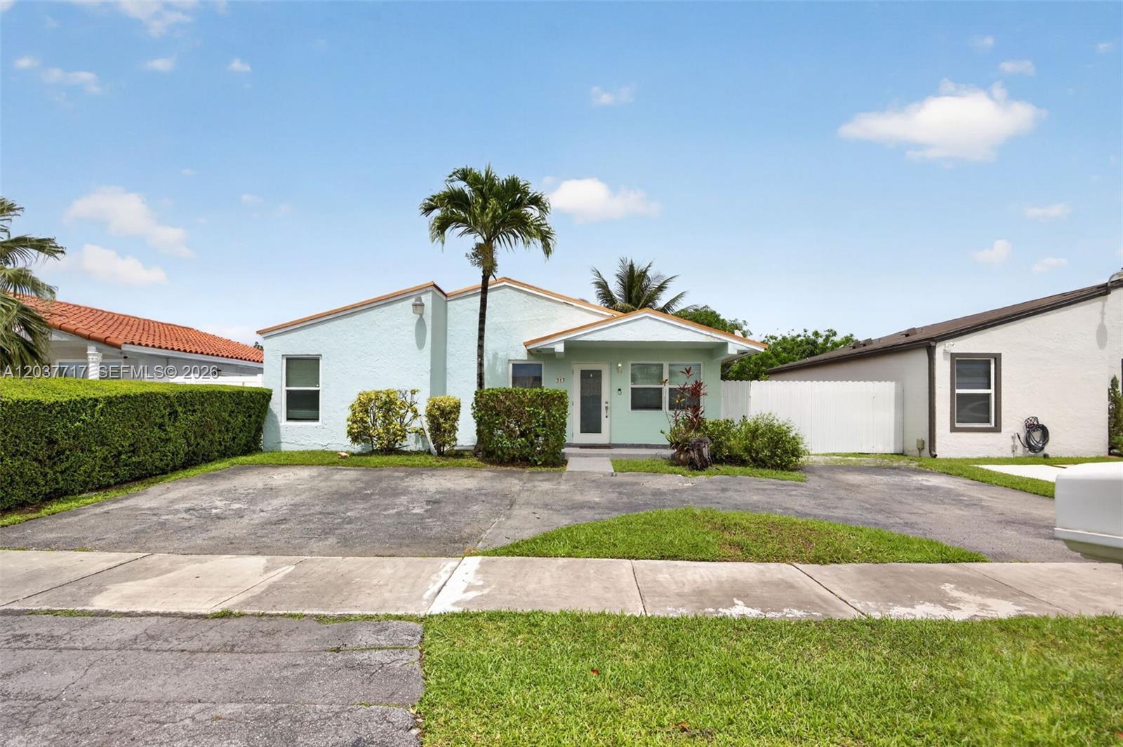A light green single-story house with a palm tree and a paved driveway — 313 NW 132nd Pl, Miami FL 33182, MIAMI, FL
