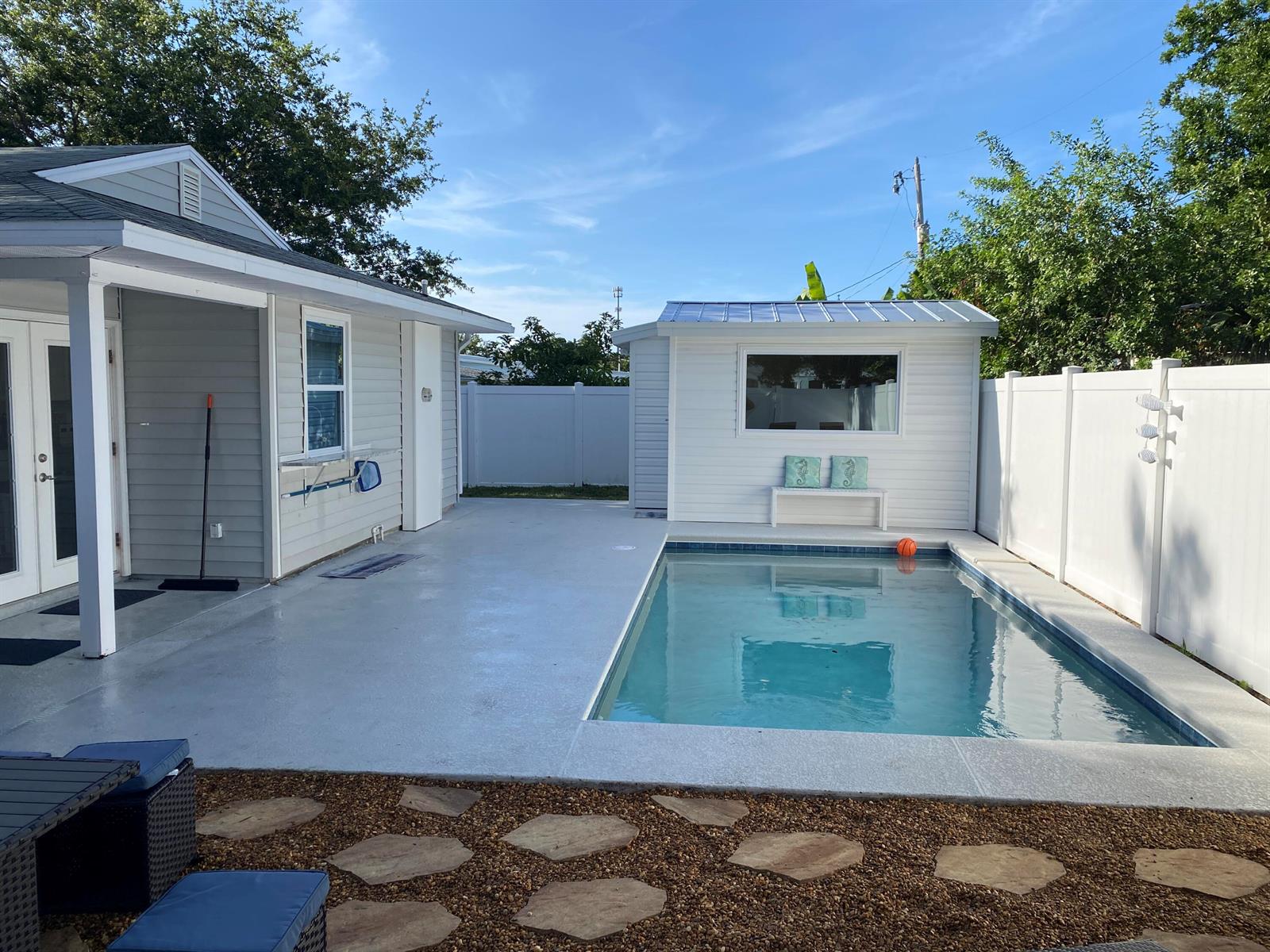 A backyard features a swimming pool, a concrete patio, and a small white detached building — 1510 3rd Court, Vero Beach FL 32960, VERO BEACH, FL
