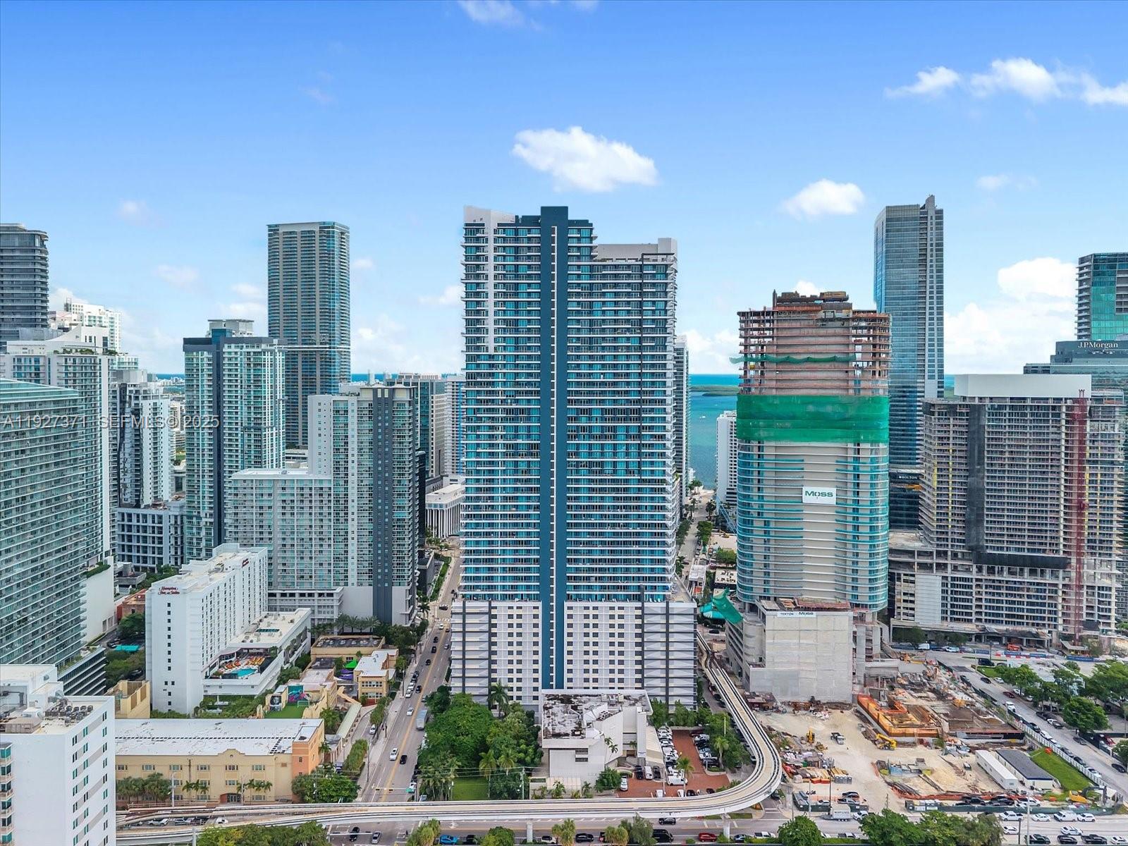 An aerial view of a dense city skyline featuring modern high-rise buildings and a monorail track — 40 SW 13th St # 202, Miami FL 33130, MIAMI, FL