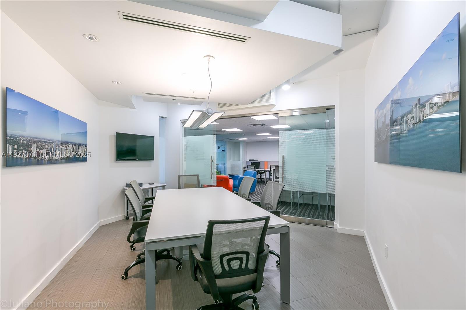 A modern conference room features a white table, mesh chairs, and two large cityscapes — 40 SW 13th St # 202, Miami FL 33130, MIAMI, FL