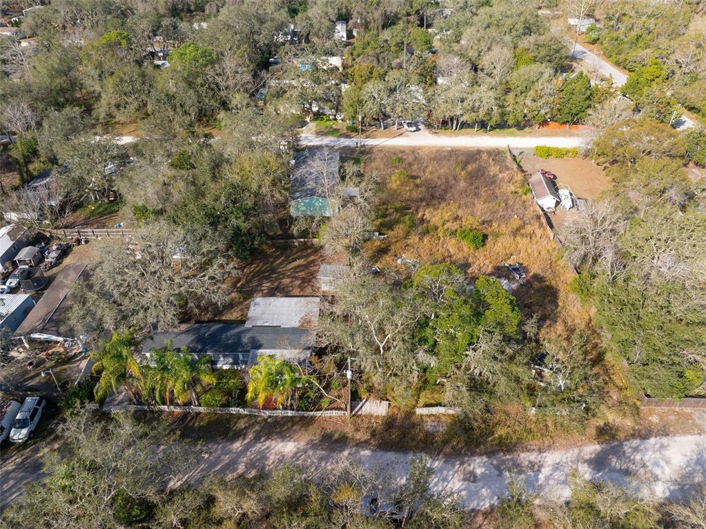 An aerial view shows a house with a large, overgrown yard and surrounding trees — 00 BURTON STREET, NEW PORT RICHEY, FL