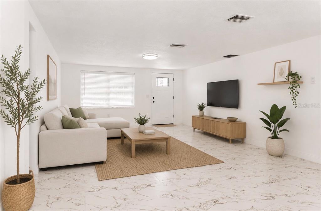 A bright living room features white walls, marble-look tile floors, a sectional sofa, and television — 4609 IRENE LOOP, NEW PORT RICHEY, FL