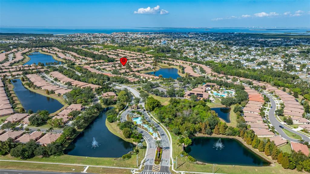 An aerial view shows a residential community with multiple ponds, a clubhouse, and surrounding homes — 5808 HIDDEN FALLS LANE, APOLLO BEACH, FL