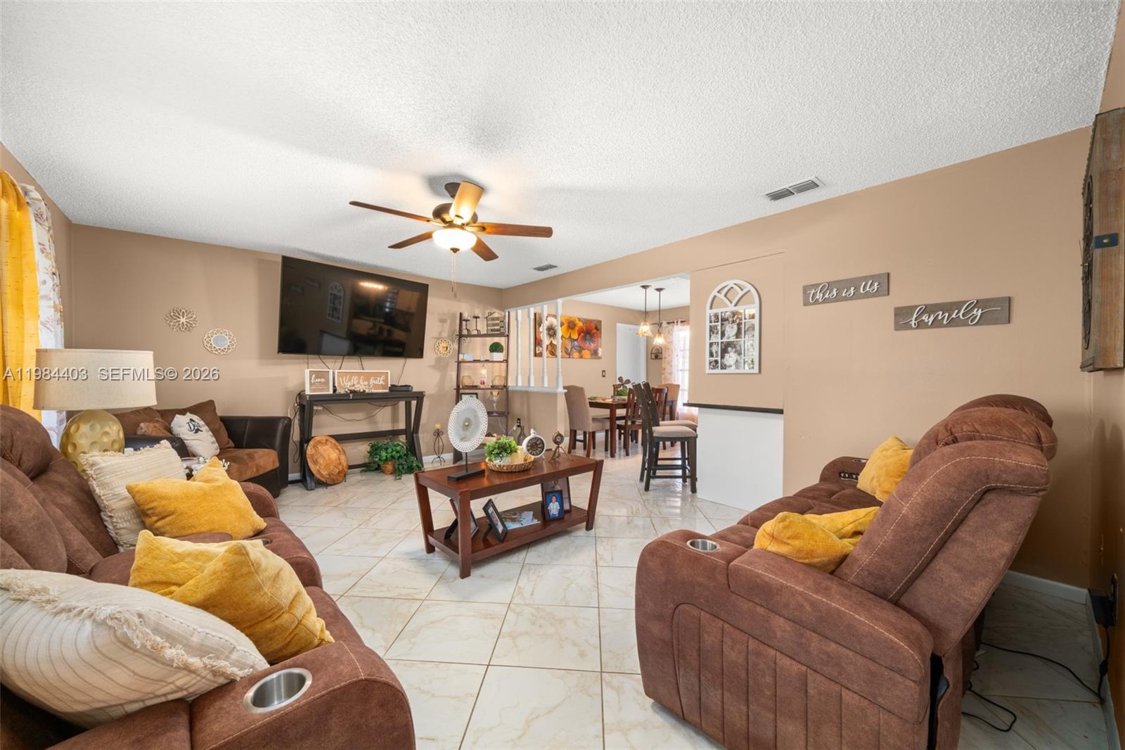 A living room features brown reclining sofas, a coffee table, and tile flooring — 4201 Westminster Road, Sebring FL Road, SEBRING, FL