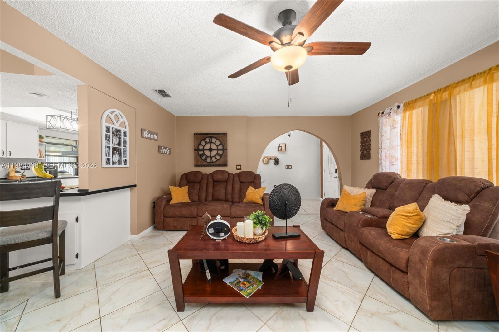 A living room features brown reclining sofas, a wooden coffee table, and tile flooring — 4201 Westminster Road, Sebring FL Road, SEBRING, FL