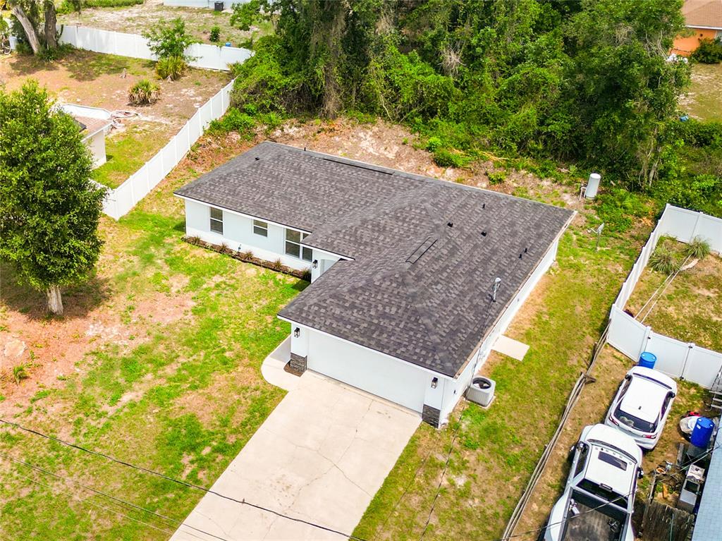 A white single-story house with a two-car garage and a grassy front yard — 13 JUNIPER PASS RADIAL, OCALA, FL