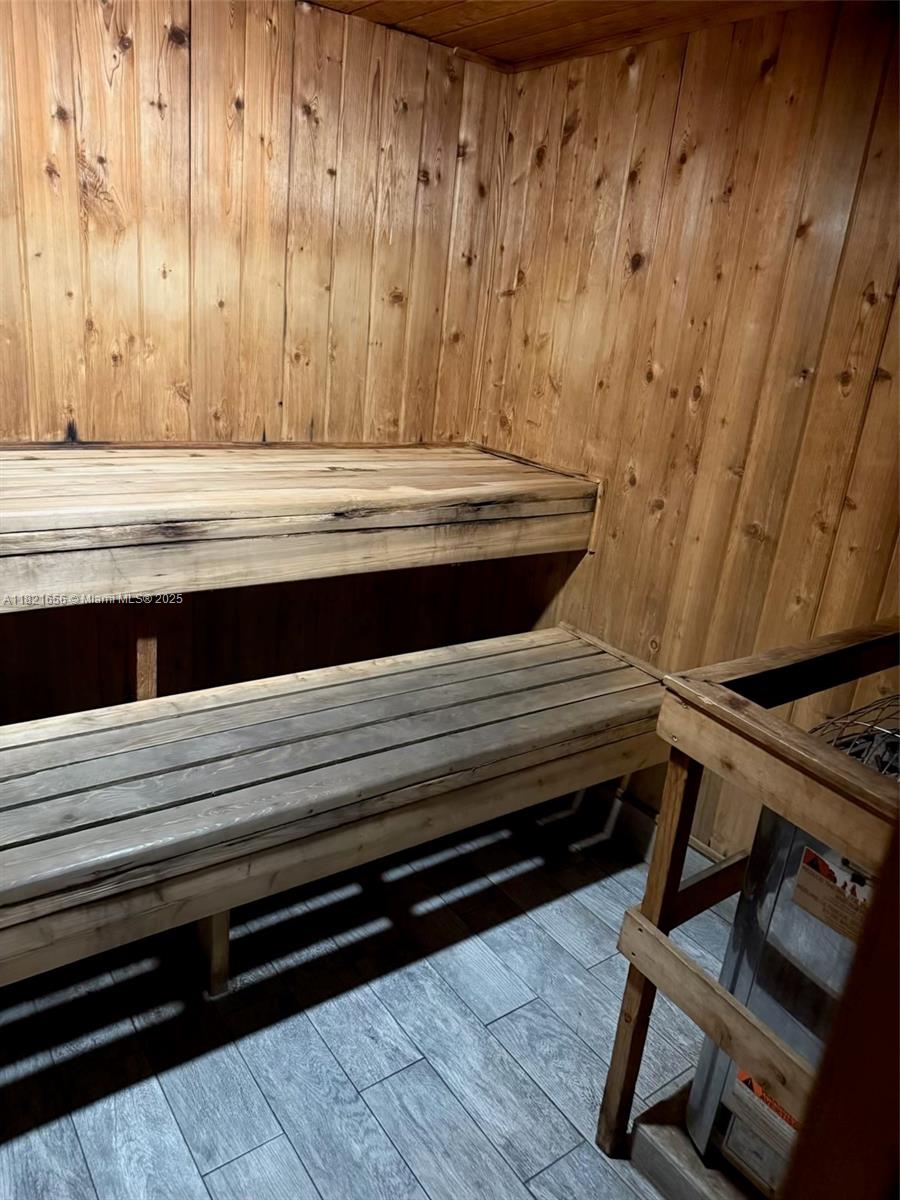 A sauna room features wood-paneled walls, two tiered wooden benches, and a metal heater — 1833 S Ocean Dr # 305, Hallandale Beach FL 33009, HALLANDALE BEACH, FL