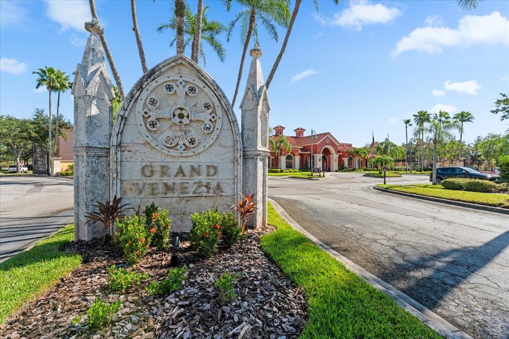 A stone monument with the name Grand Venezia stands at the entrance to a community — 2747 VIA CAPRI UNIT 1132, CLEARWATER, FL