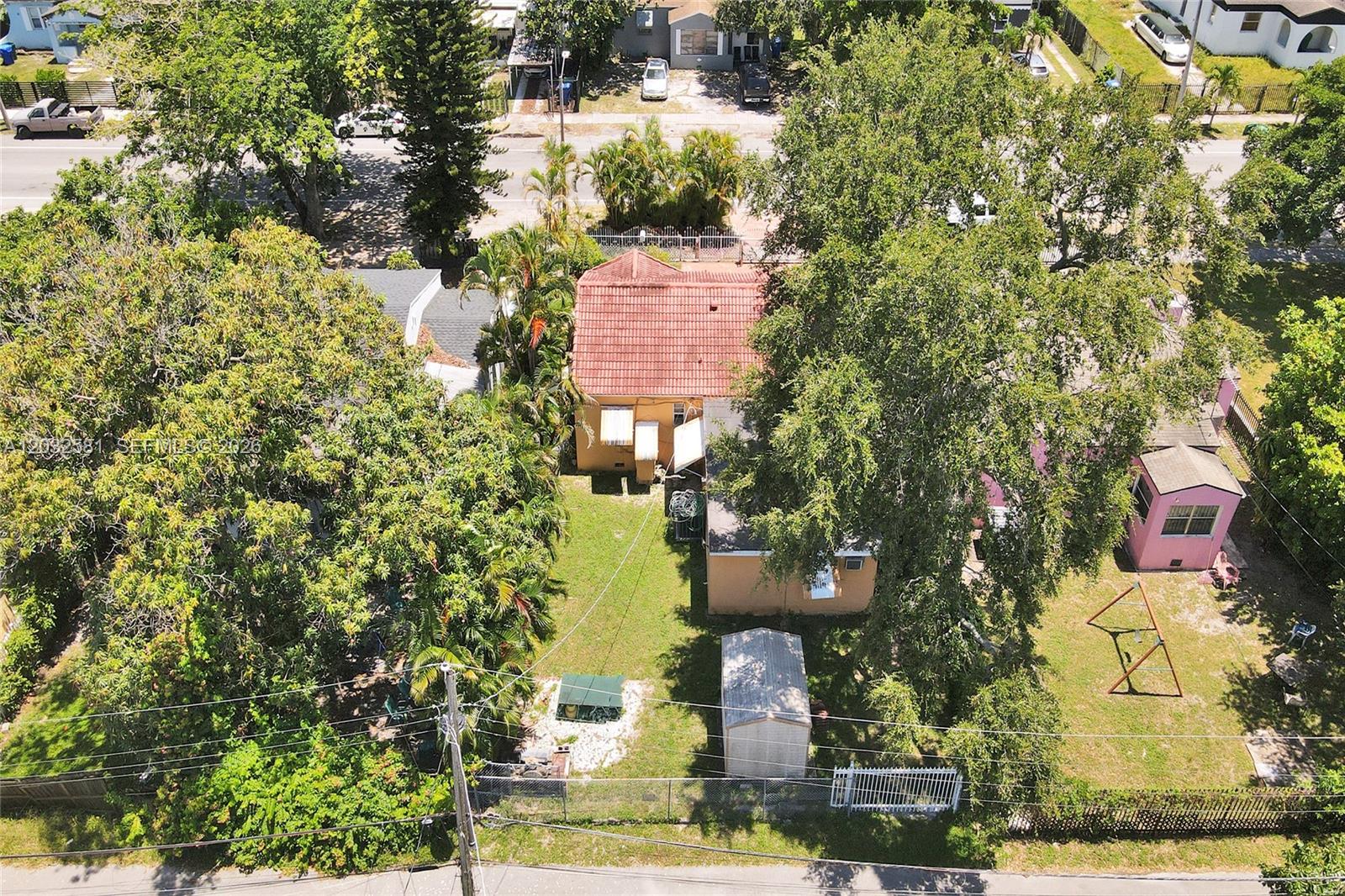 An aerial view shows a house with a red tile roof and a backyard — 555 NW 46th St, Miami FL 33127, MIAMI, FL