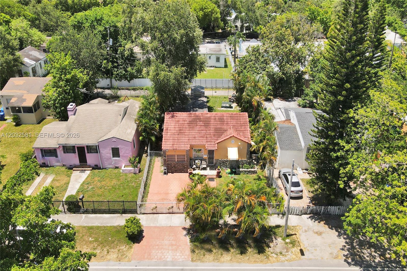 An aerial view shows two adjacent single-story houses with tiled roofs and front yards — 555 NW 46th St, Miami FL 33127, MIAMI, FL