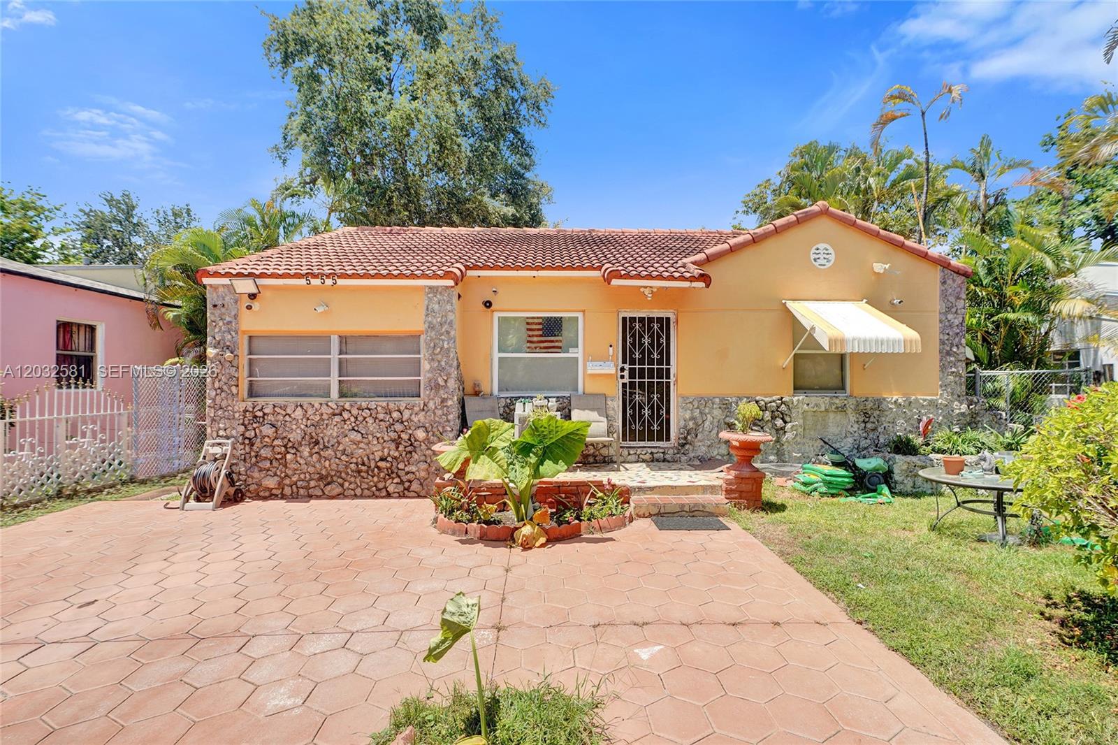 A single-story house with a peach-colored exterior, stone accents, and a red tile roof — 555 NW 46th St, Miami FL 33127, MIAMI, FL