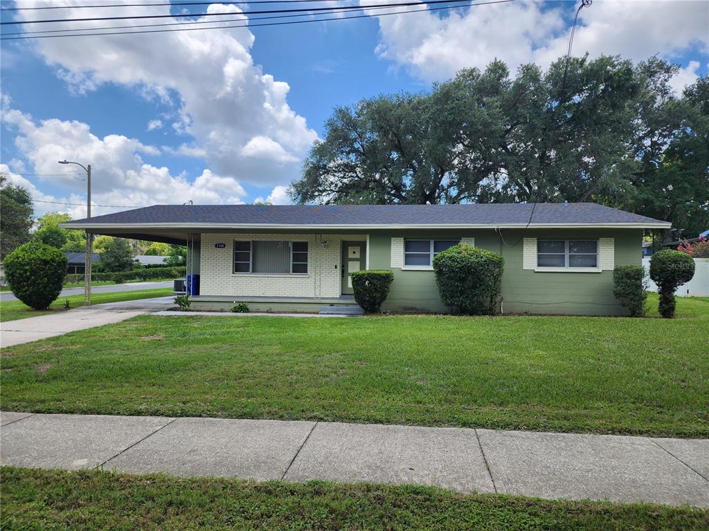 A single-story house with a green exterior, a carport, and a front lawn — 1104 W 14TH STREET, LAKELAND, FL
