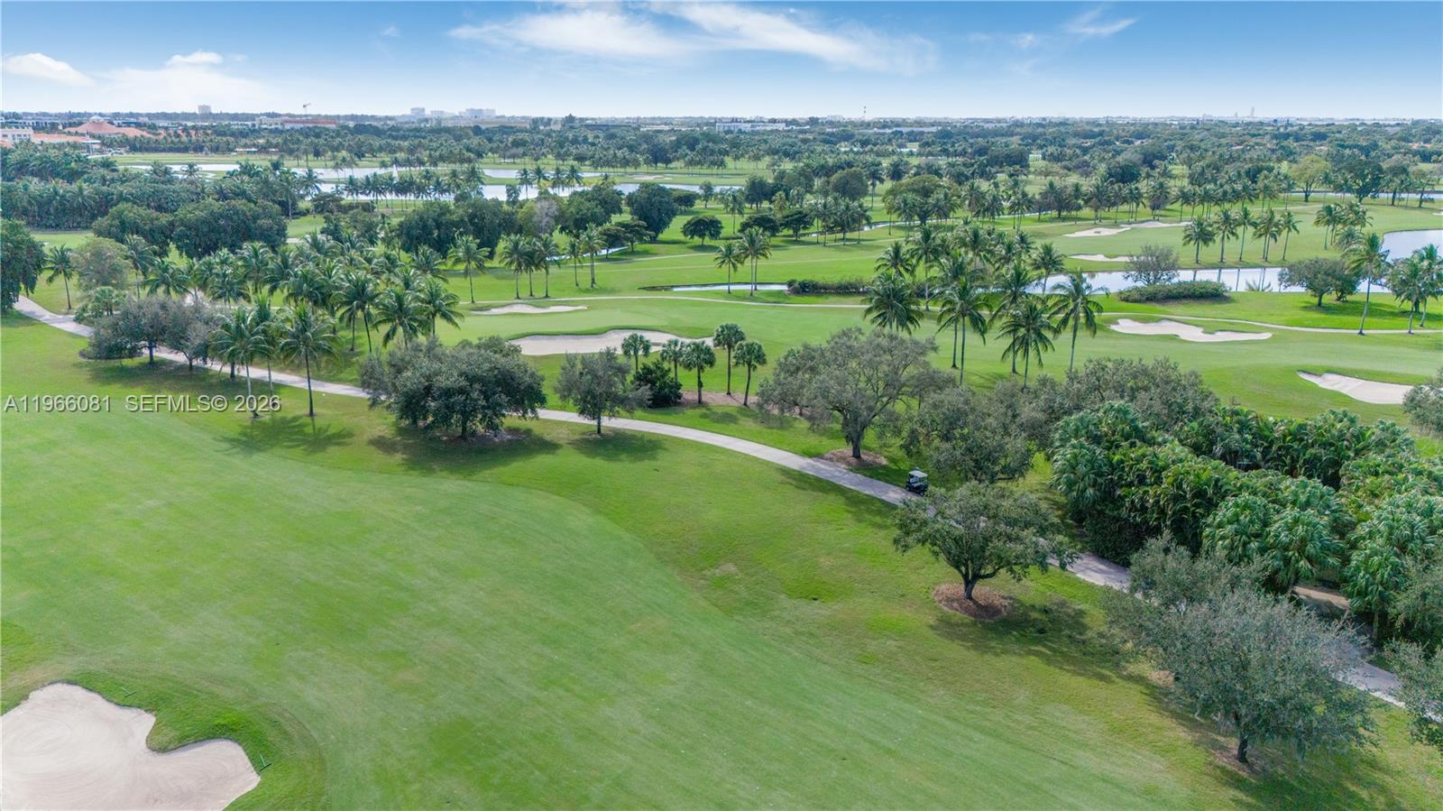 An aerial view shows a golf course with green fairways, sand traps, and palm trees — 5300 NW 87th Ave # 108, Doral FL 33178, DORAL, FL