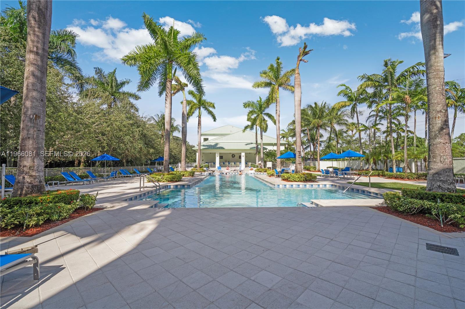A rectangular swimming pool is surrounded by a paved deck, palm trees, and lounge chairs — 5300 NW 87th Ave # 108, Doral FL 33178, DORAL, FL