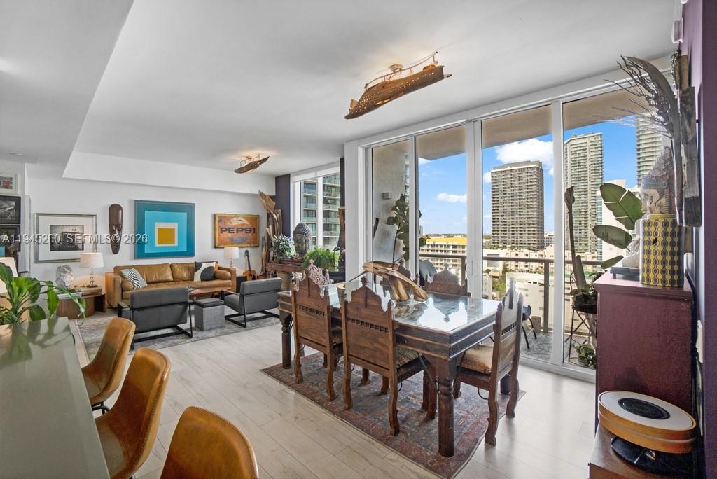 An open-concept living and dining area features wood furniture, light flooring, and floor-to-ceiling windows — 601 NE 27th St # 1505, Miami FL 33137, MIAMI, FL