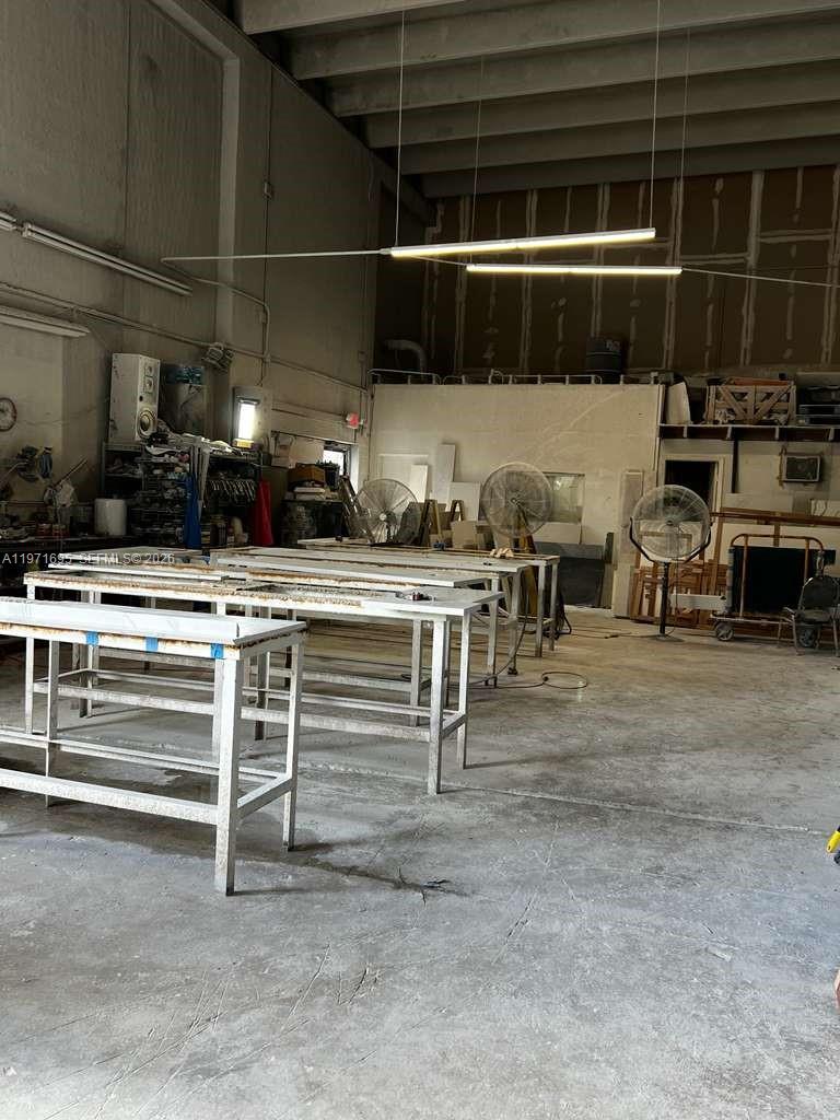 This industrial workshop features multiple metal workbenches, concrete floors, and overhead fluorescent lighting — 5301 NW 15 ST, Margate FL 33063, MARGATE, FL