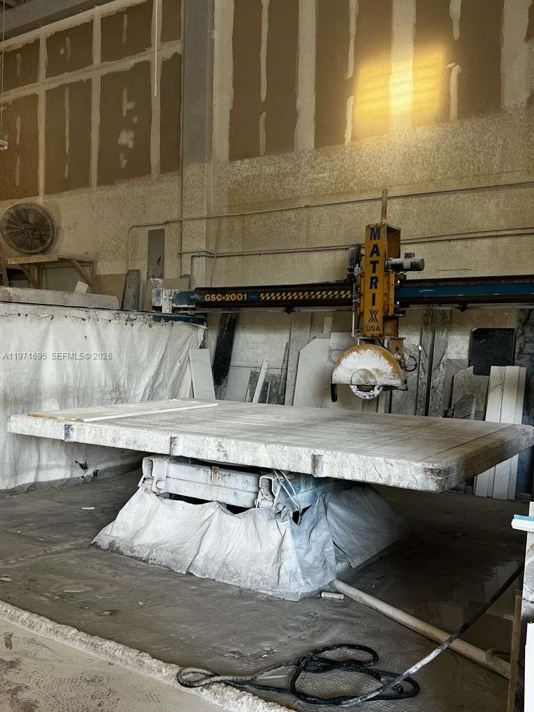 A large industrial stone-cutting machine sits in a workshop with unfinished walls — 5301 NW 15 ST, Margate FL 33063, MARGATE, FL