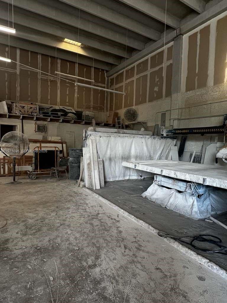 An industrial workshop features a large stone-cutting machine, concrete floors, and unfinished drywall walls — 5301 NW 15 ST, Margate FL 33063, MARGATE, FL