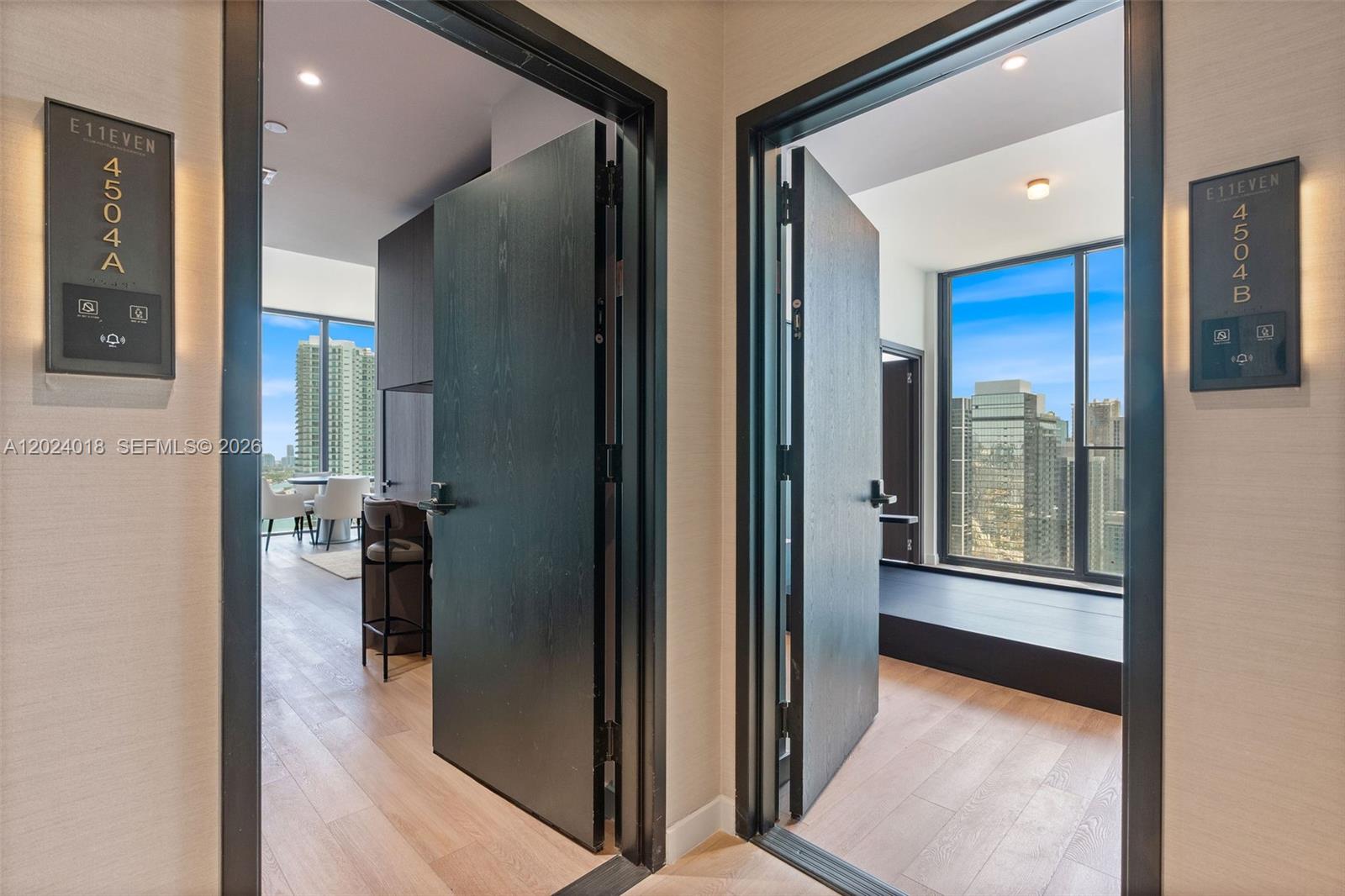 Two modern apartment entryways with dark wood doors and floor-to-ceiling windows overlooking a city — 20 NE 11th 20 NE 11TH ST # 4504, Miami FL 33132, MIAMI, FL