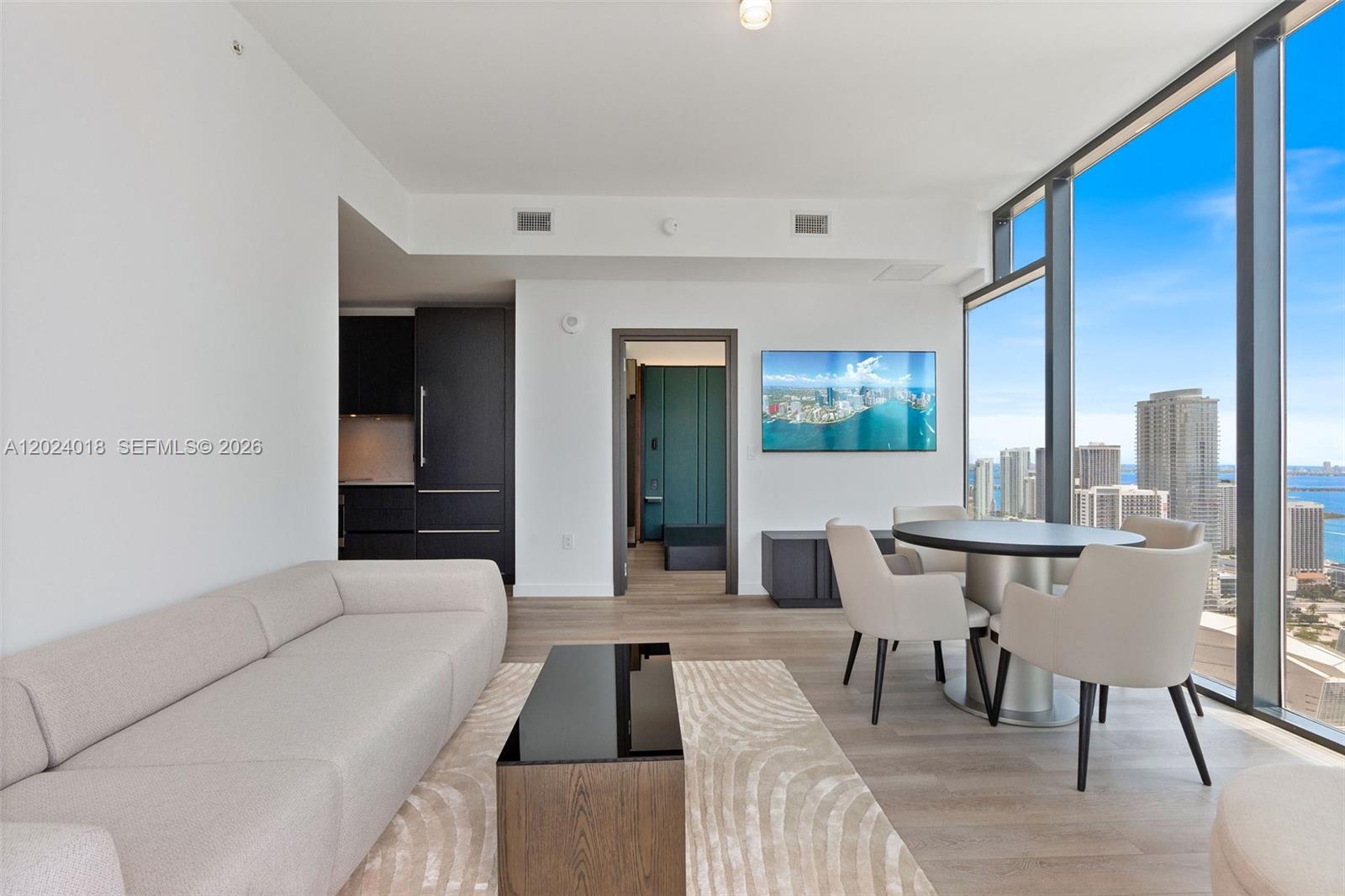 A modern living and dining area features floor-to-ceiling windows with a city and water view — 20 NE 11th 20 NE 11TH ST # 4504, Miami FL 33132, MIAMI, FL