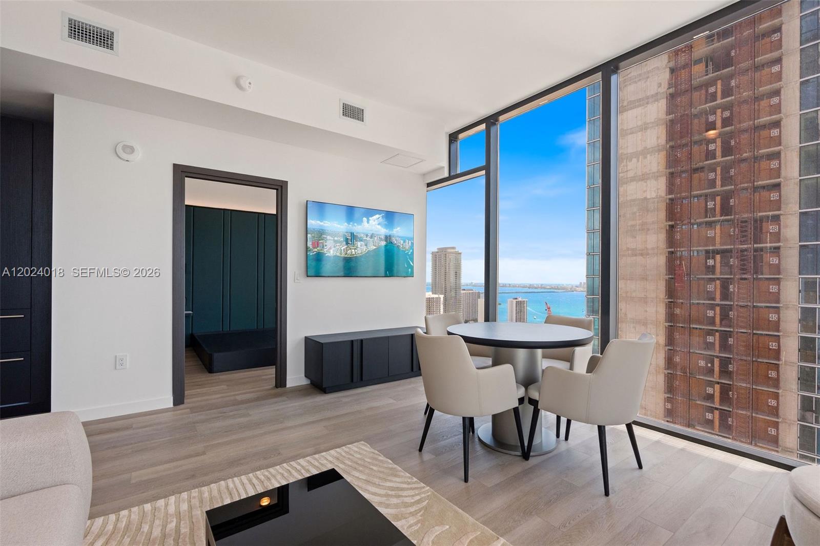 A modern dining area features a round table, four chairs, and floor-to-ceiling windows with views — 20 NE 11th 20 NE 11TH ST # 4504, Miami FL 33132, MIAMI, FL
