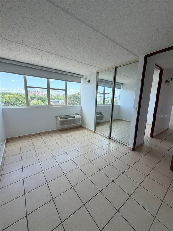 A room with tiled floors, a large window, and mirrored sliding closet doors — #850 CALLE EIDER UNIT A808, SAN JUAN, PR