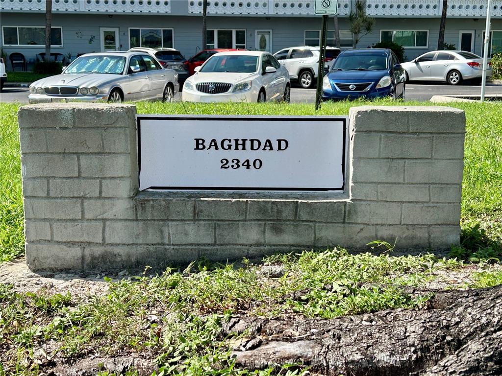 A concrete sign displaying the name Baghdad and the number 2340 sits before a parking lot — 2340 GRECIAN WAY UNIT 38, CLEARWATER, FL