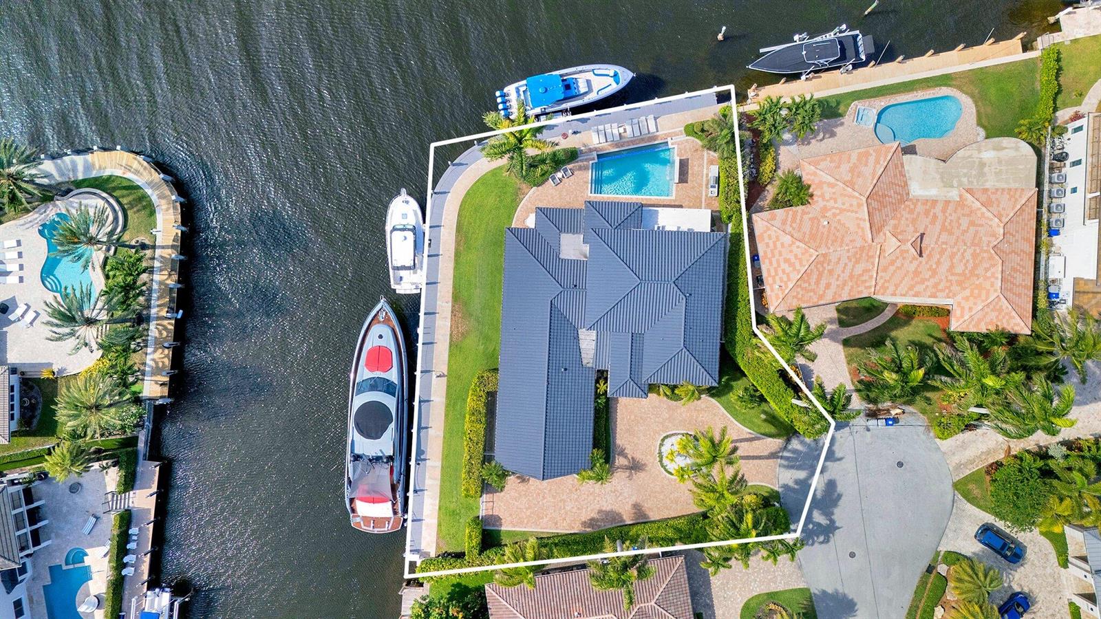 An aerial view shows a waterfront house with a pool, dock, and two moored boats — 2593 SE 9th Street, Pompano Beach FL 33062, POMPANO BEACH, FL