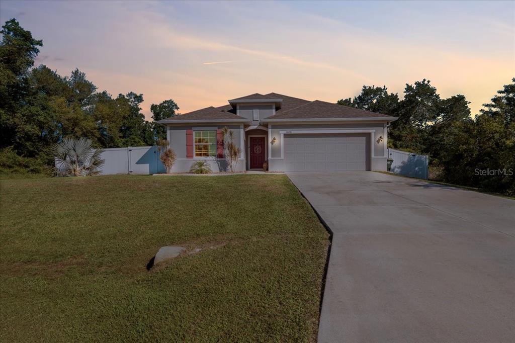 A single-story house with a gray exterior, a two-car garage, and a concrete driveway — 3476 BREWSTER ROAD, NORTH PORT, FL