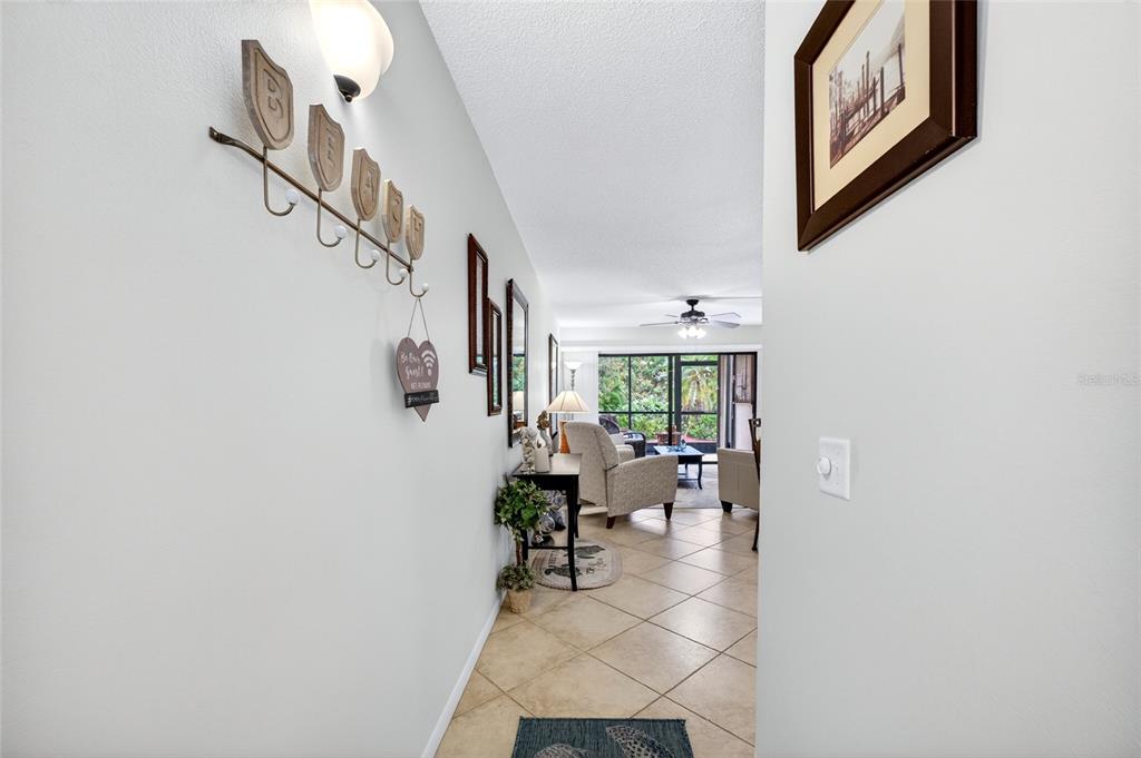A view from a hallway looking into a living room with tile flooring and patio — 6365 BAHIA DEL MAR BOULEVARD UNIT 106, ST PETERSBURG, FL