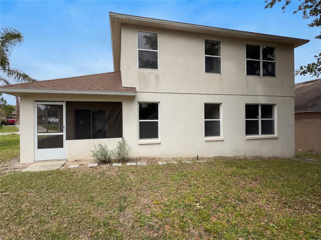 The exterior of a two-story house with a screened-in porch and a grassy yard — 1021 DEKLEVA DRIVE, APOPKA, FL