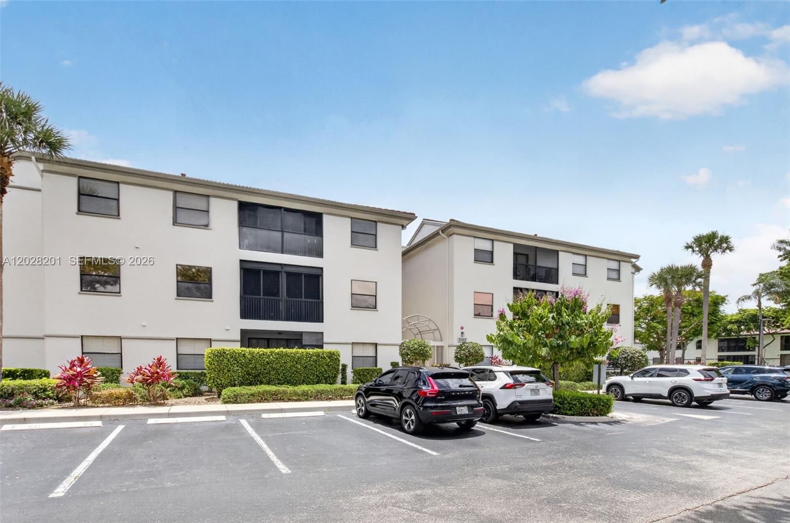 A three-story apartment building with a parking lot in the foreground — 5133 Brisata Cir # L, Boynton Beach FL 33437, BOYNTON BEACH, FL