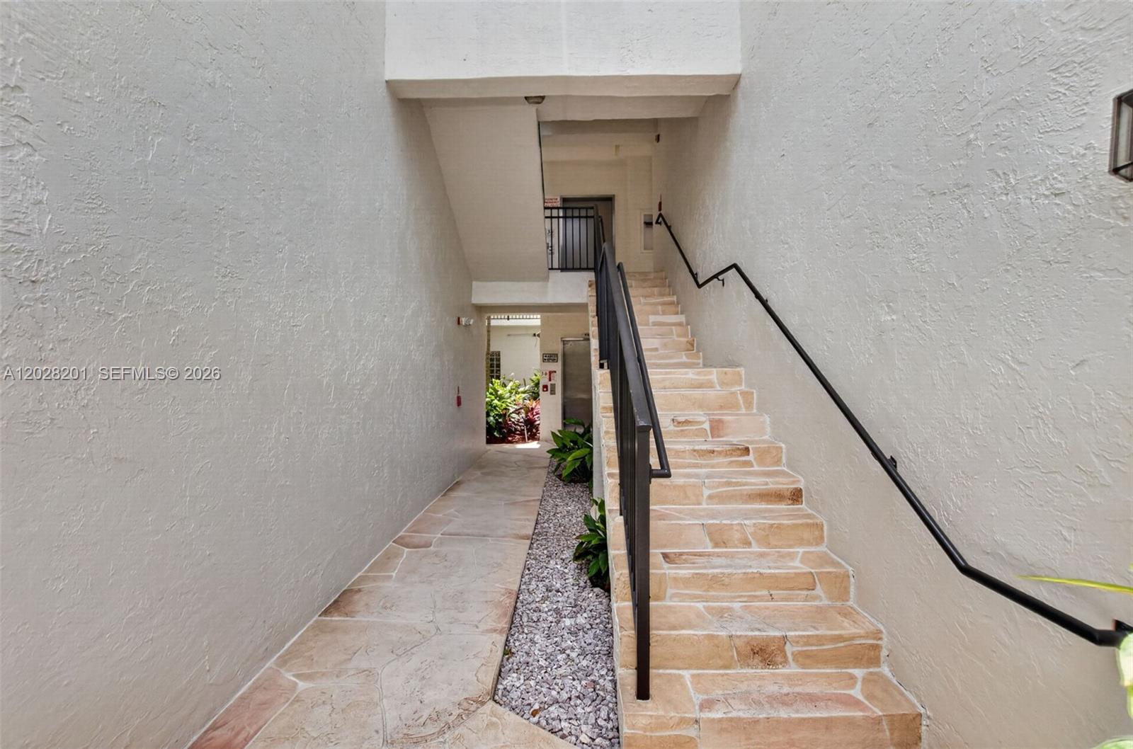 An outdoor staircase with stone steps and a metal railing leads to an upper level — 5133 Brisata Cir # L, Boynton Beach FL 33437, BOYNTON BEACH, FL