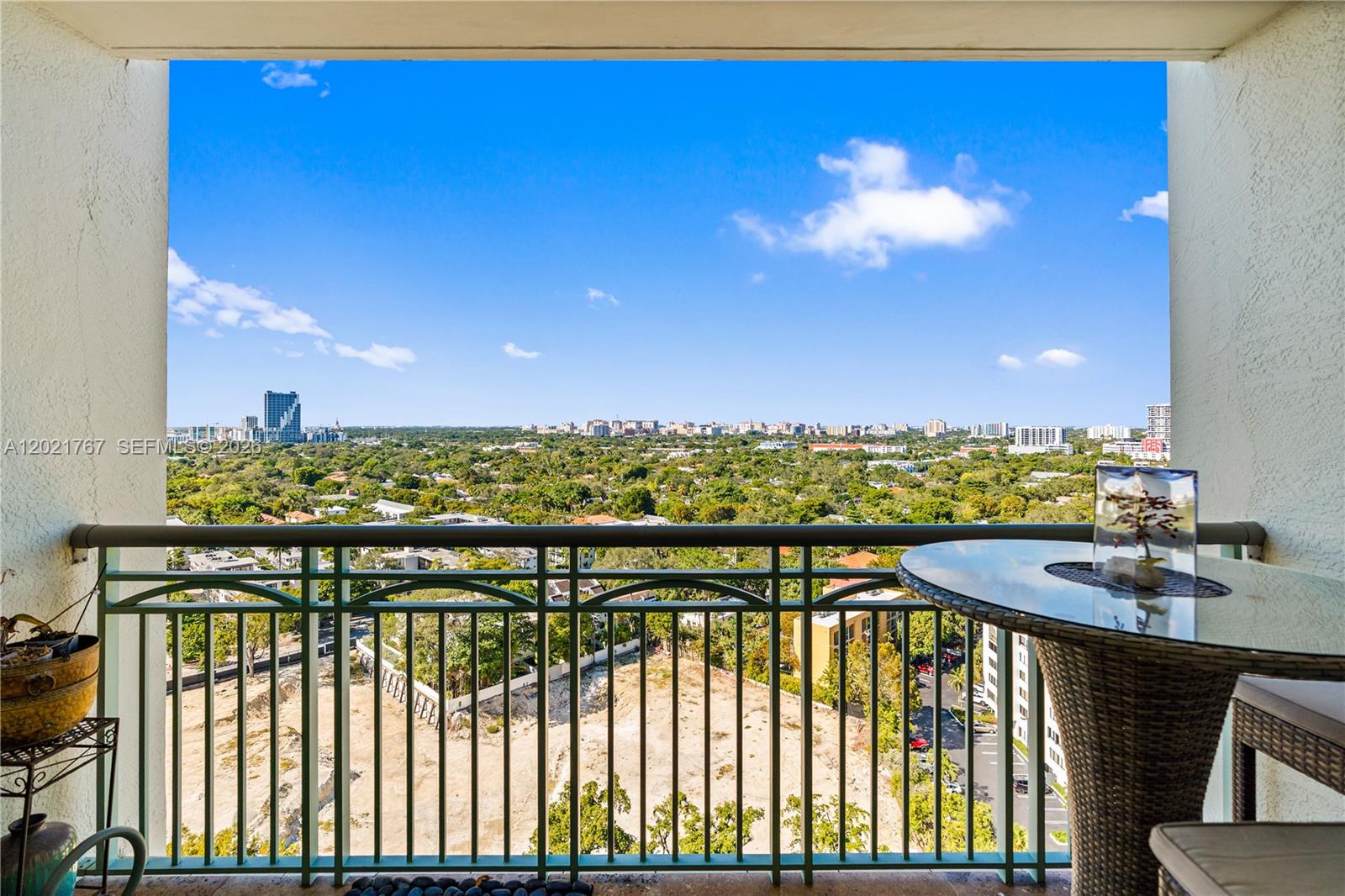 A balcony with a metal railing overlooks a city skyline and a large wooded area — 3350 SW 27th Ave # 1706, Coconut Grove FL 33133, COCONUT GROVE, FL