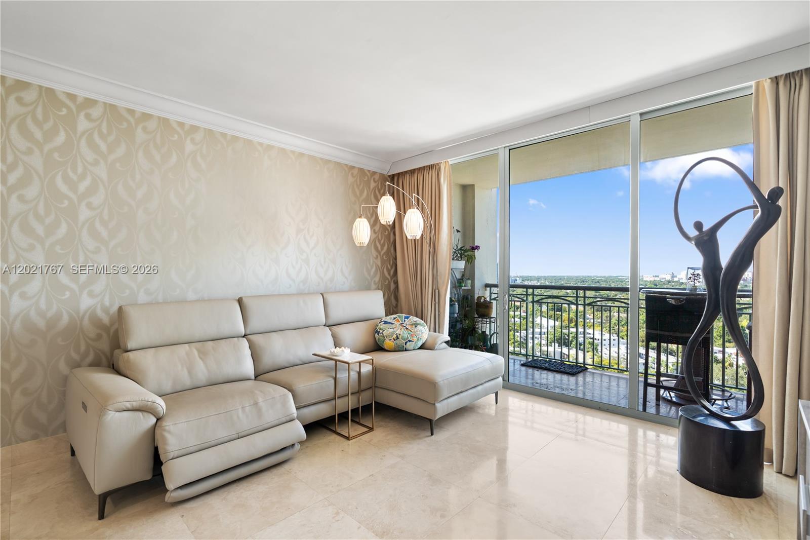 A balcony with a glass-topped table and wicker chairs overlooks a city and green landscape — 3350 SW 27th Ave # 1706, Coconut Grove FL 33133, COCONUT GROVE, FL