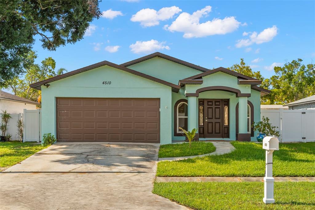 A light green single-story house with a brown garage door and a covered front entryway — 4510 68TH AVENUE N, PINELLAS PARK, FL