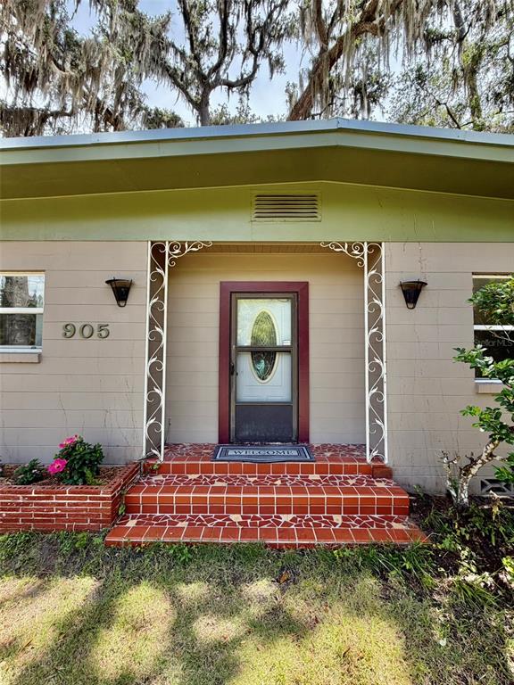 The exterior of a house features a red tiled porch, a decorative metal frame, and siding — 905 NW 36TH AVENUE, GAINESVILLE, FL