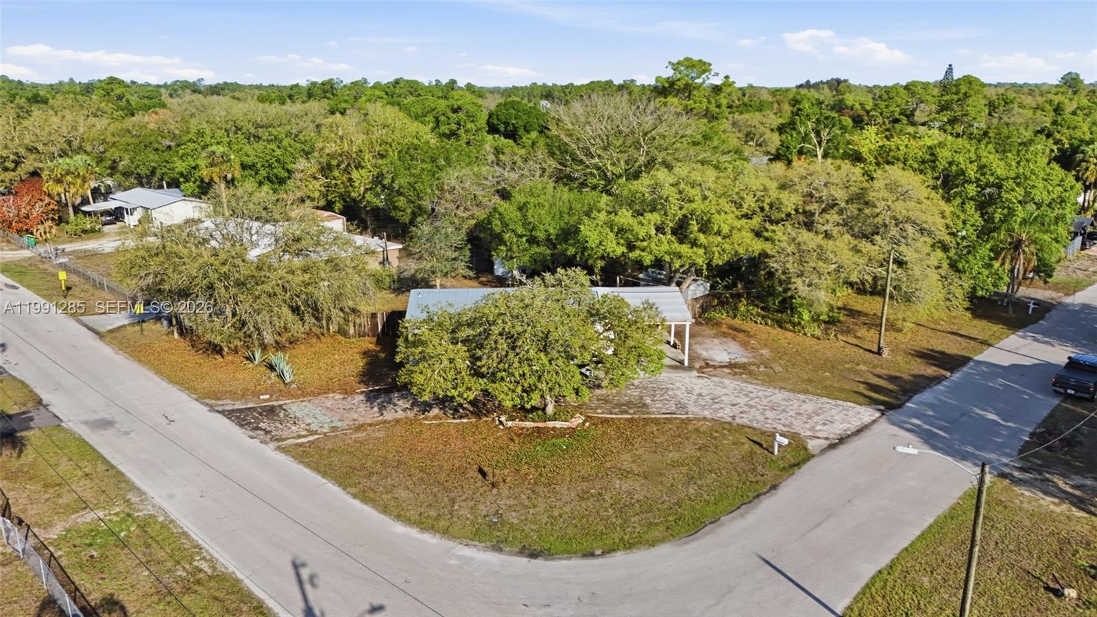 An aerial view shows a house with a metal roof and a paved driveway — 740 bennett ave, La Belle FL 33935, LA BELLE, FL