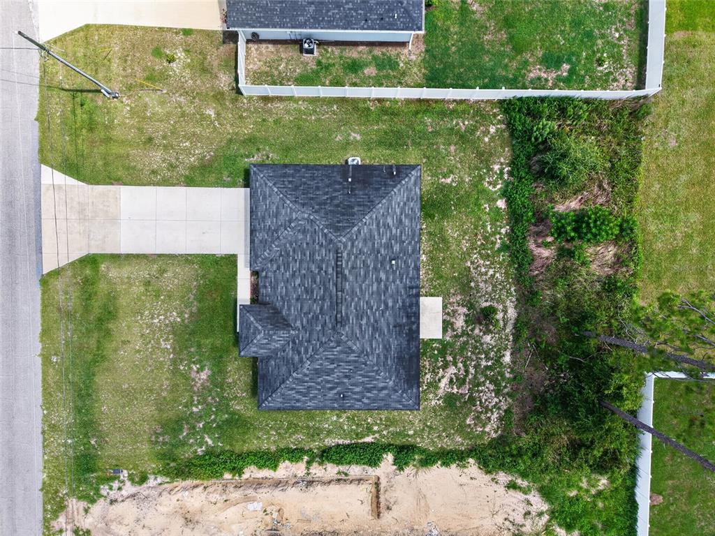 An aerial view shows a house with a dark shingled roof, driveway, and surrounding yard — 8111 SW 132ND LOOP, OCALA, FL