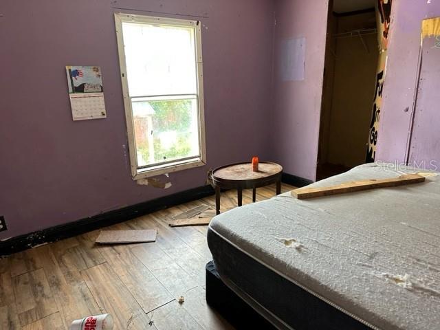 A bedroom with purple walls, a window, a small table, and a mattress on the floor — 10207 E PIKE DRIVE, INVERNESS, FL