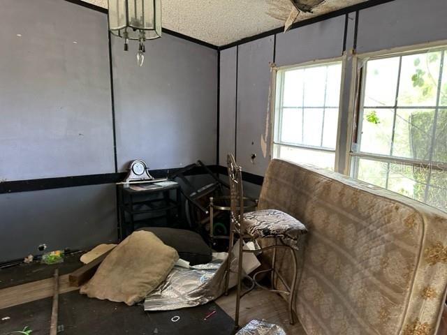 An interior room with gray paneled walls, a mattress, and a high-backed chair — 10207 E PIKE DRIVE, INVERNESS, FL