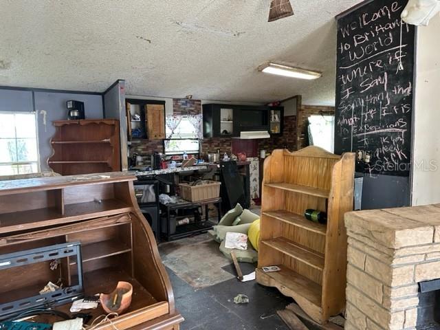 A cluttered room features a wooden roll-top desk, a bookshelf, and a large chalkboard wall — 10207 E PIKE DRIVE, INVERNESS, FL