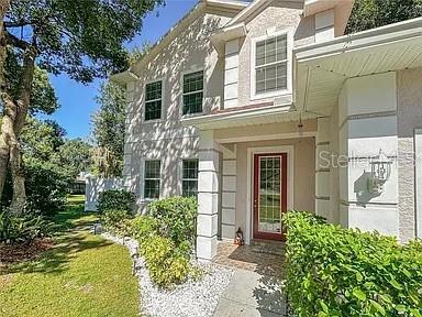 A two-story house with a red front door, white trim, and a landscaped front yard — 21915 BELL LAKE ROAD UNIT 2, LAND O LAKES, FL