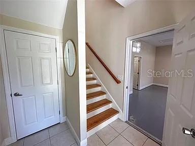 An entryway features a white door, a staircase with wooden treads, and a doorway leading inside — 21915 BELL LAKE ROAD UNIT 2, LAND O LAKES, FL