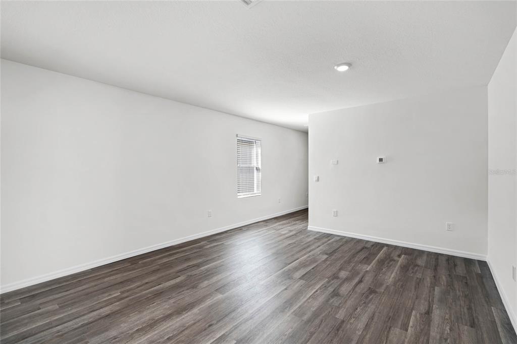 An empty room with white walls, gray wood-look flooring, and a single window — 1660 HUMMINGBIRD ROAD, WINTER HAVEN, FL