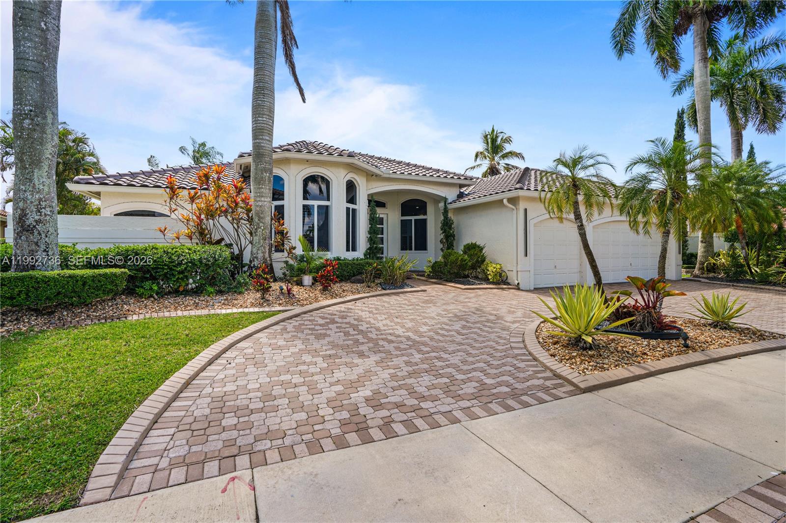 A single-story house with a paved circular driveway, arched windows, and palm trees — 2569 Eagle Run Ln # 0, Weston FL 33327, WESTON, FL