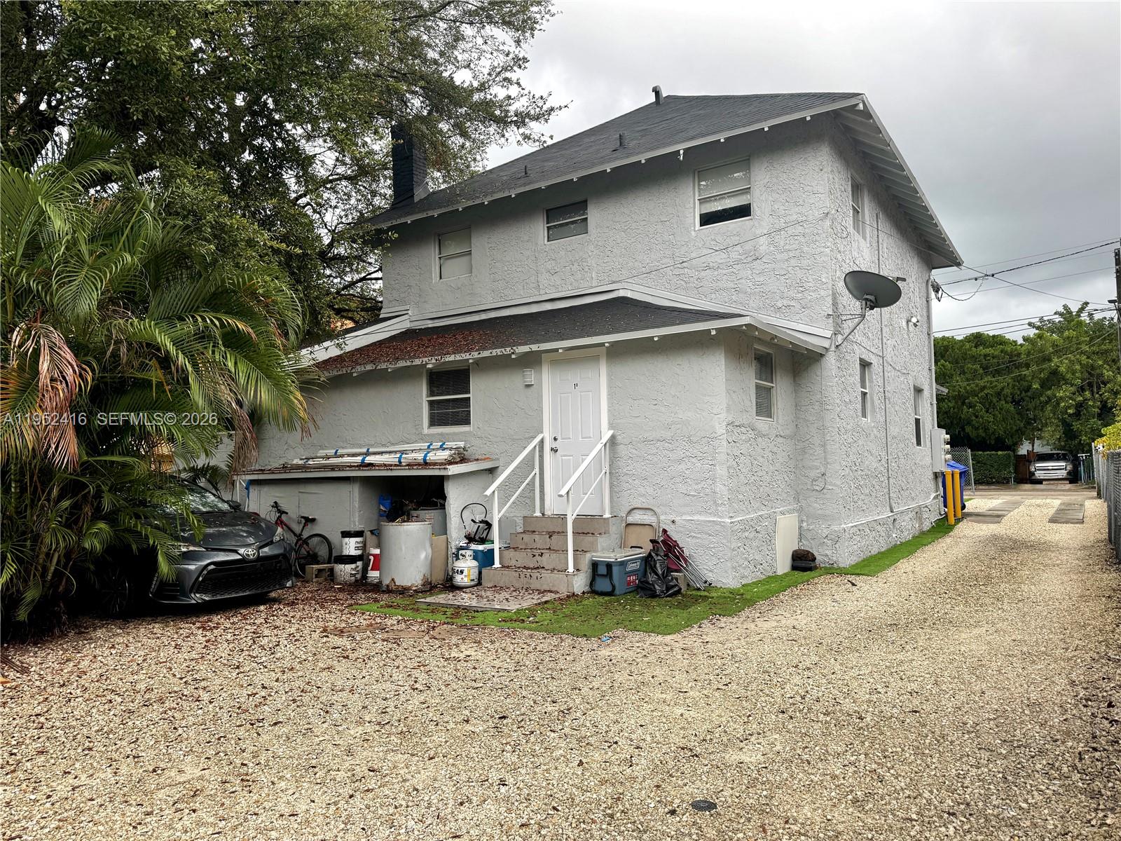 A two-story light gray house with a gravel front yard and a concrete walkway — 529 SW 3rd St, Miami FL 33130, MIAMI, FL