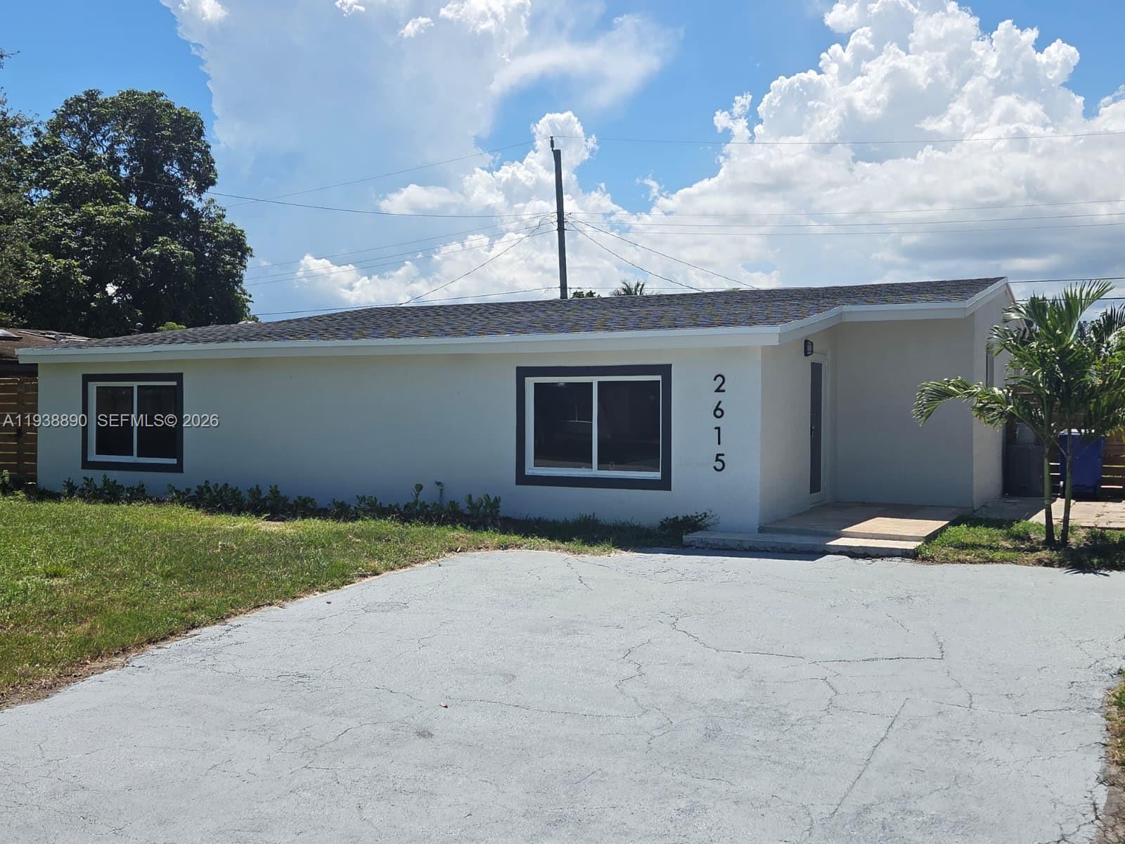 A single-story house with a white exterior, dark trim, and a paved driveway — 2615 NW 62nd Ave, Margate FL 33063, MARGATE, FL