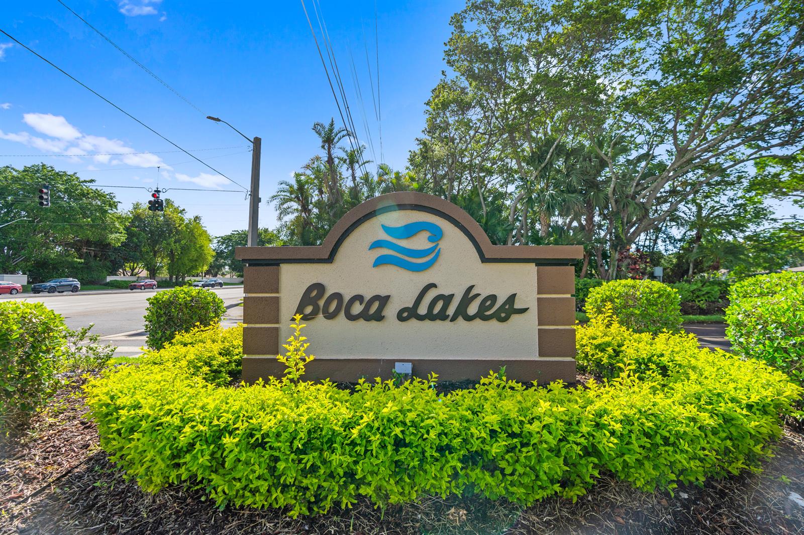 A tan monument sign with the text Boca Lakes stands surrounded by green landscaping — 8666 Bella Vista Drive # 111, Boca Raton FL 33433, BOCA RATON, FL